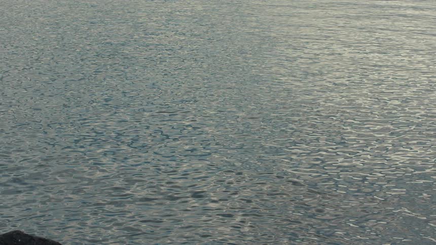 Reflection of the sun in the ocean with calm waters