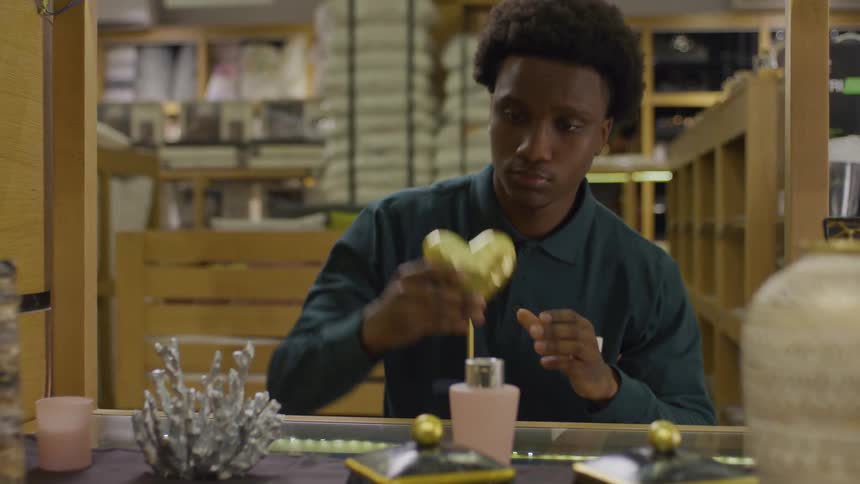 Man placing objects on a display in a store