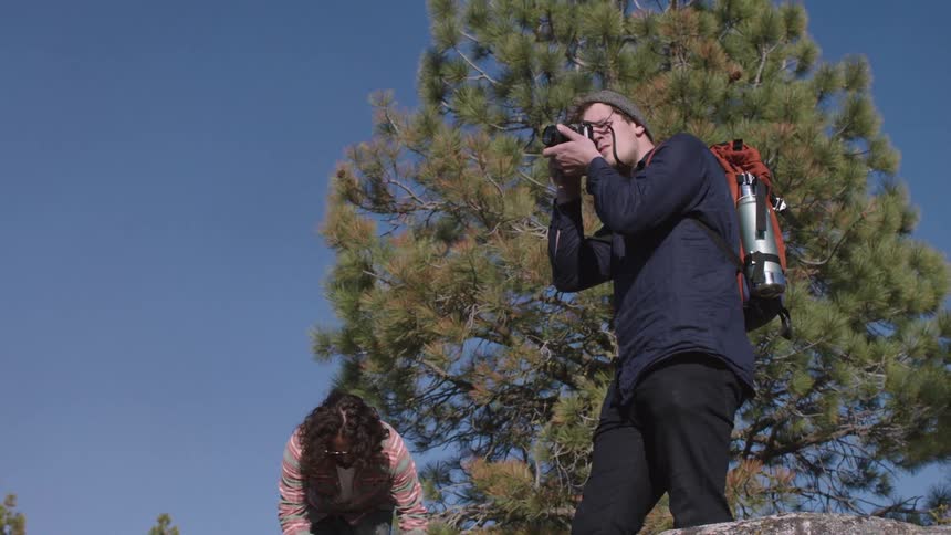 People walk up a rock to take pictures of scenery