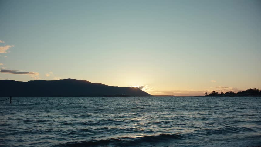 Beach at dawn with the silhouette of mountains on the horizon