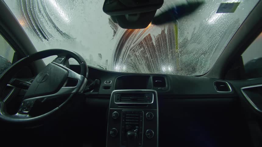 Interior view of a vehicle with the windshield being washed