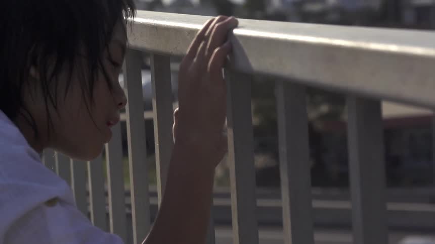 A child looks through a metal fence