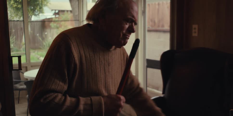 Elderly man cleaning the house and singing happily