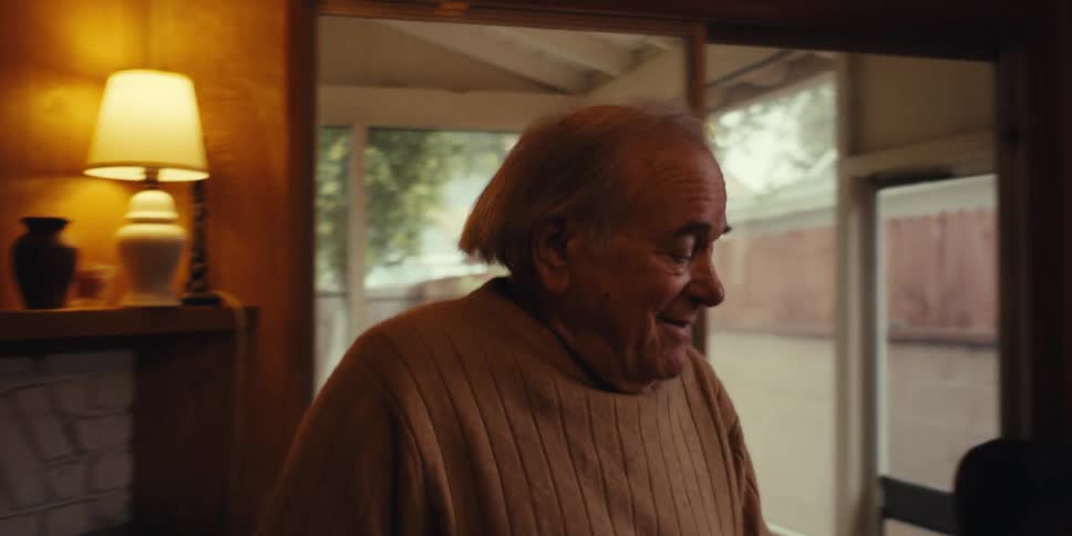 Elderly man dancing and cleaning the living room