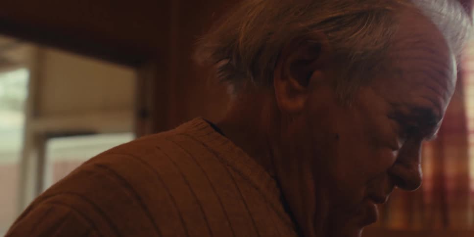 Elderly man cleaning the house while singing