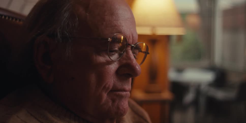 Elderly man sitting with focus using cell phone