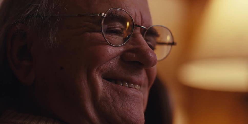 A clip of an elderly man smiling while looking at a smartphone