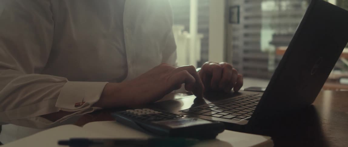 Man uses the touch pad of his laptop while in his office
