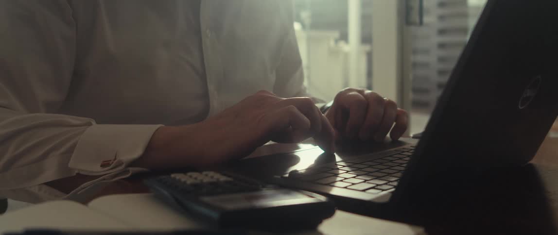 Man uses his laptop touch pad to scroll while in his office