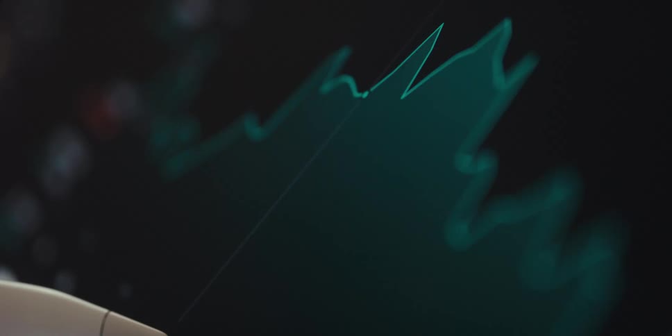 A stylus pointing at a glowing financial chart on a dark digital screen emphasizing data analysis and market trends