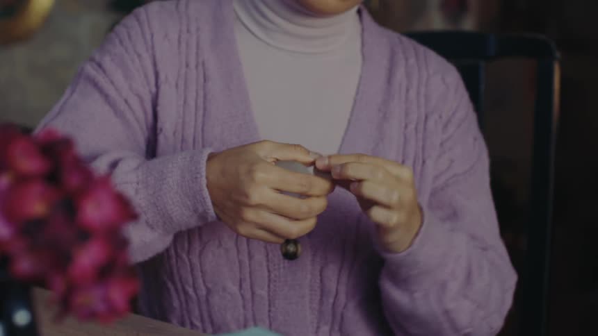 Woman handling a small object with her hands