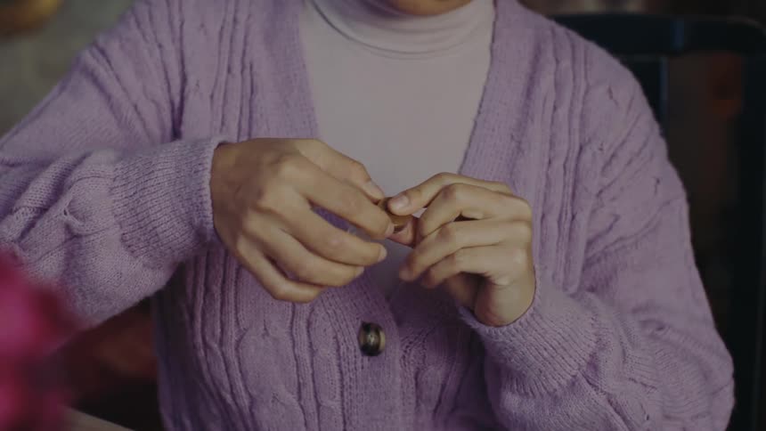 Pair of womans hands interacting with a small abstract object