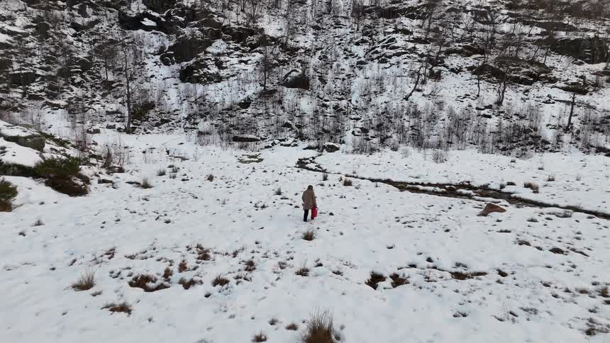 Lone person walking through a snowy mountainous area