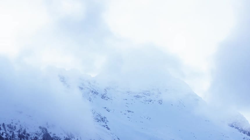 Low lying clouds obscure snowy mountains on a winter day