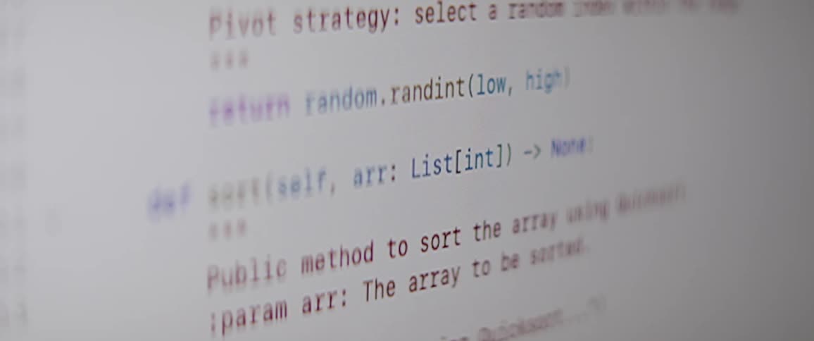 A closeup of a computer screen displays a section of python code with functions scrolling up