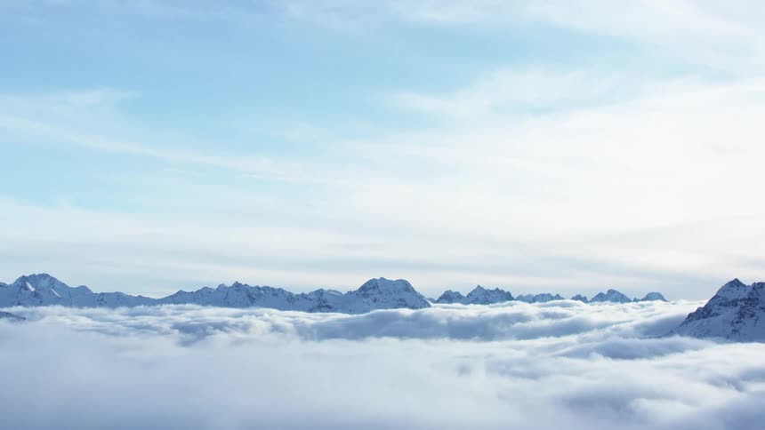 An aerial perspective reveals mountain peaks shrouded in clouds