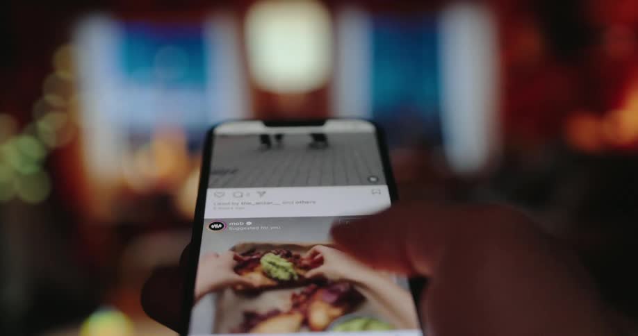 A mans thumb is endlessly scrolling down a social media feed