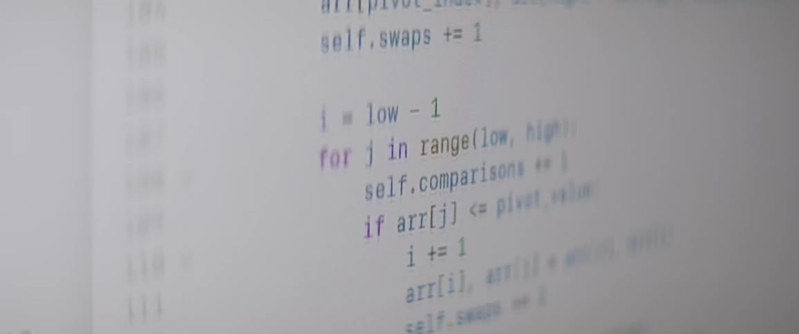 A closeup of a computer screen displays a section of python code with functions scrolling up