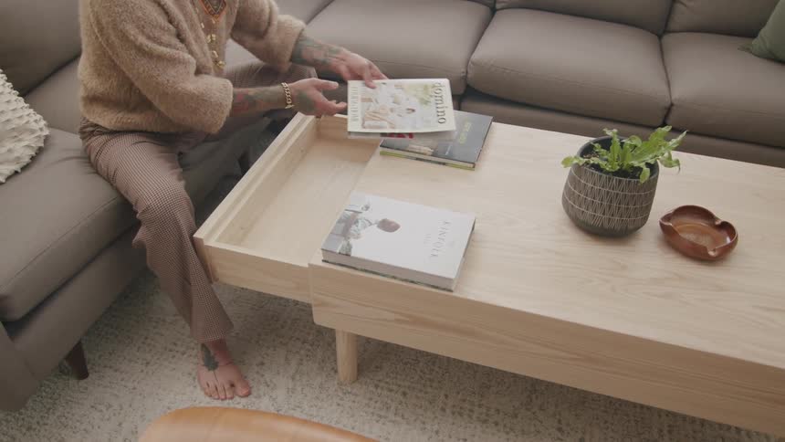 Person removes a publication from a coffee table drawer