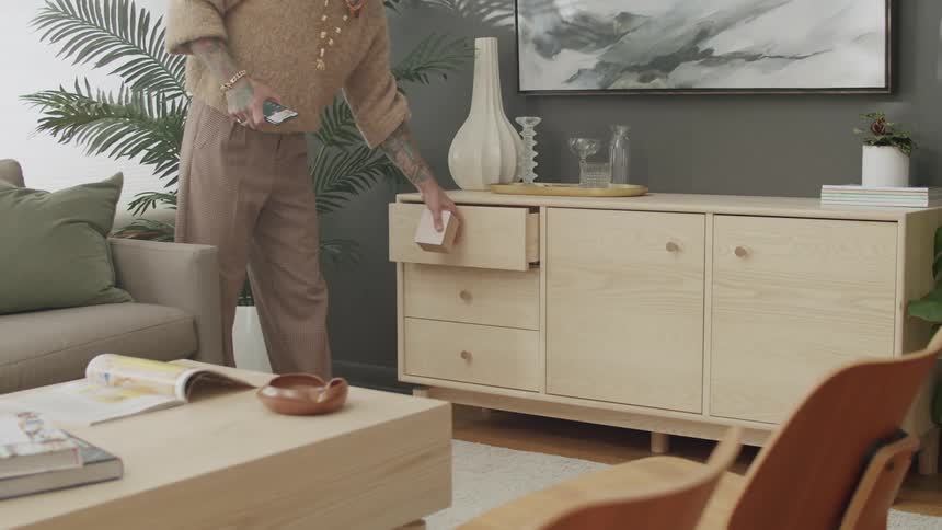 Person putting a small box in a drawer of a cabinet