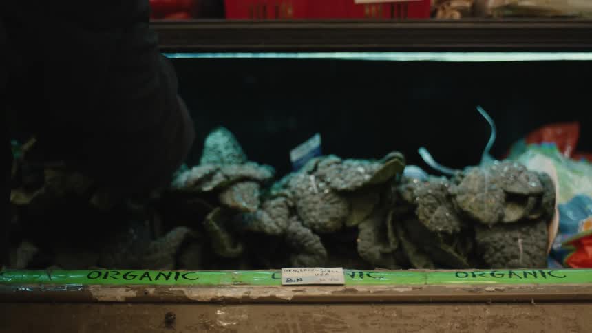 A person picks a leaf vegetable at the market