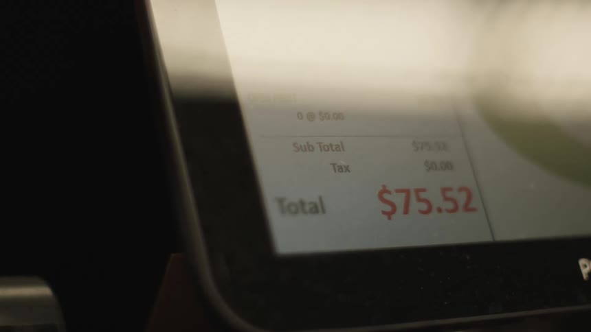 A closeup of a pointofsale terminal screen displaying the total amount