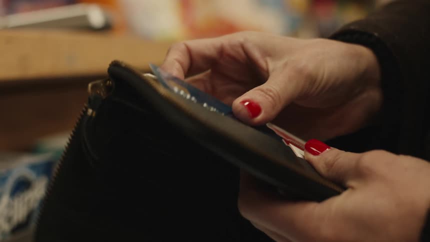 A woman is using a credit card to pay