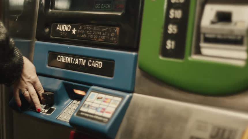 Woman wearing a winter coat uses an atm machine