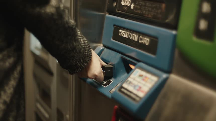 Person inserting and withdrawing a card from an atm