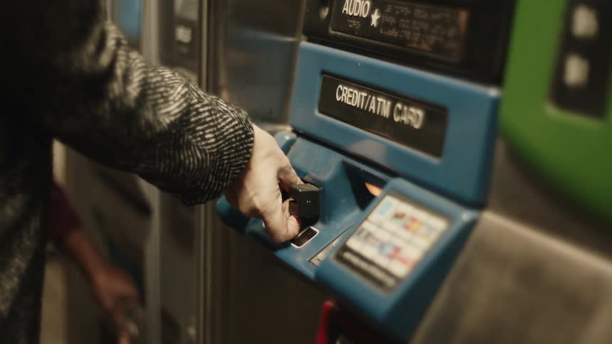 A person is using a ticket vending machine in a subway station