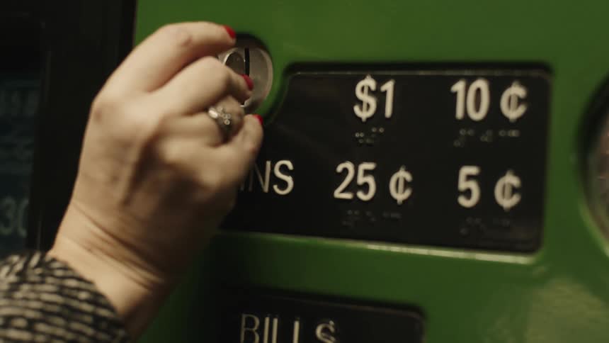 A woman puts a coin into the machine