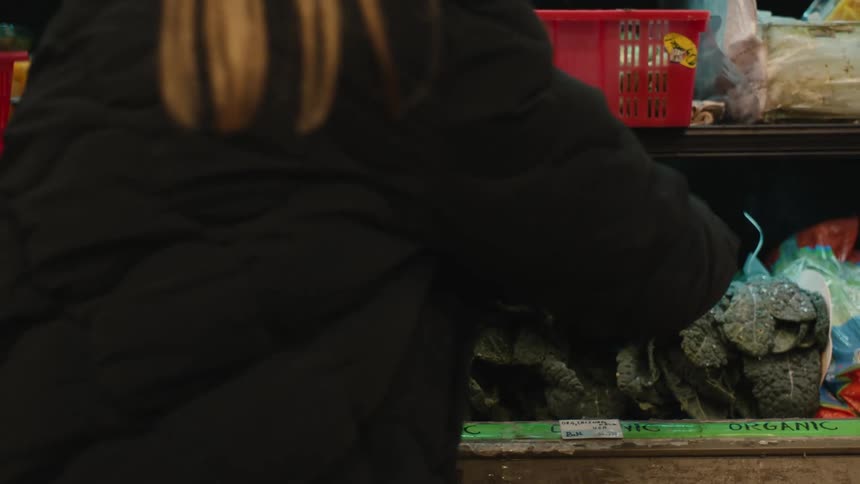 A woman is shopping for vegetables