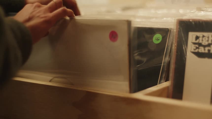 A woman is flipping through records in the store