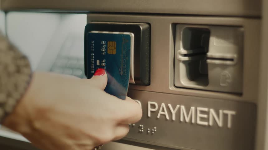 Hand with a card approaching an atm