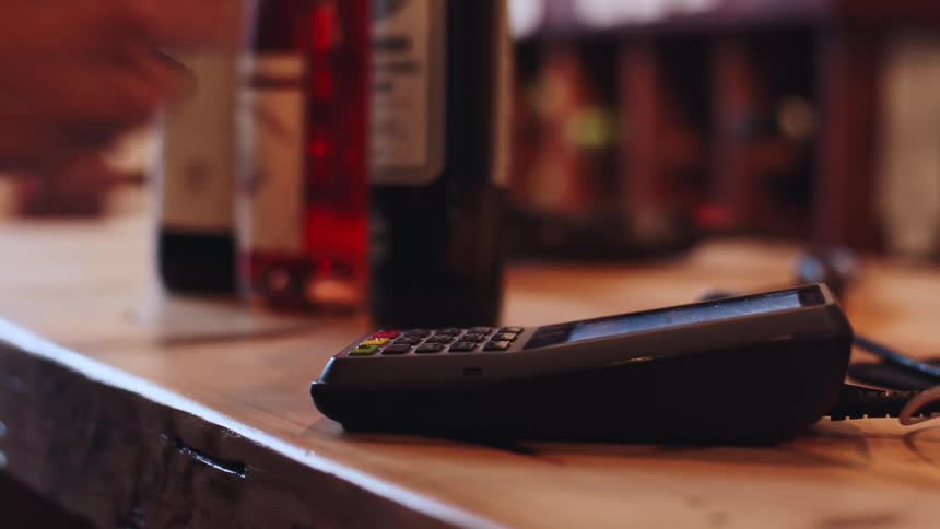 Hand approaching card into a payment machine