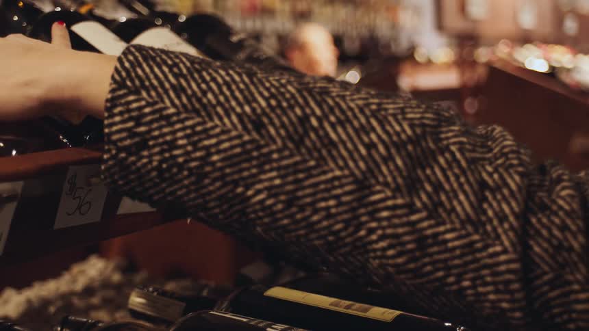 An image of a person selecting wine at the wine store