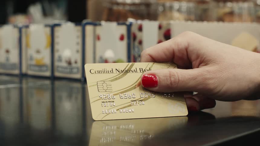 A customer taps their credit card on the shop counter