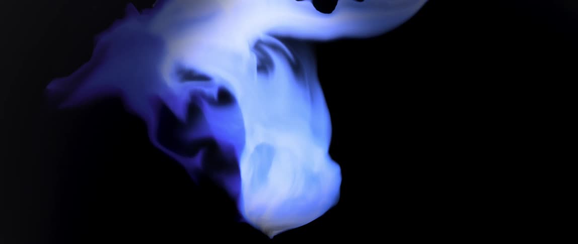 Abstract whitish ink expanding against a black background
