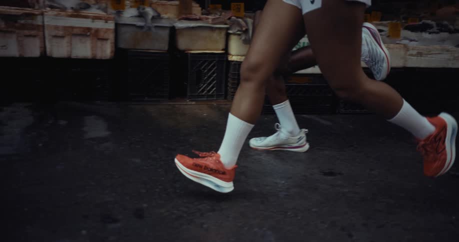 Legs of two runners in sports shoes running on the street