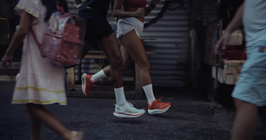 Legs of a man and a woman running on a city street
