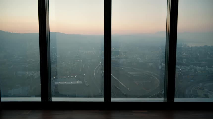 Urban view through a window with soft lighting on the horizon in the background