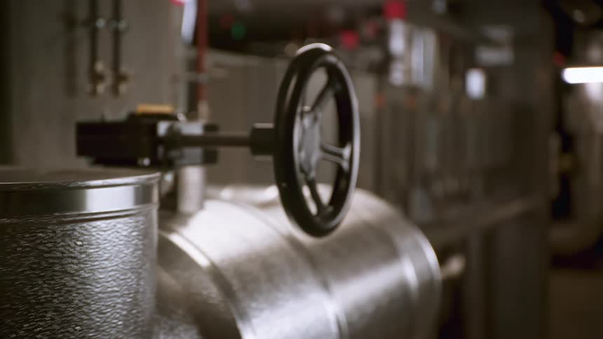 Interior view of two valves on metal pipes in a factory