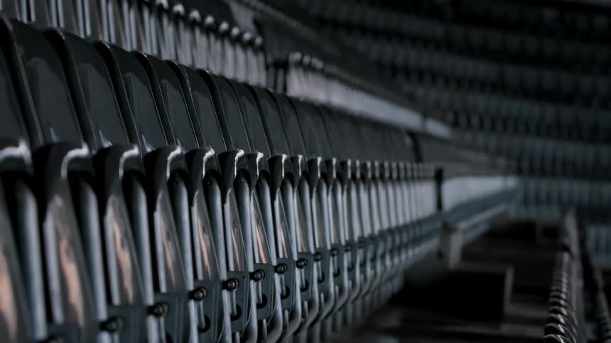 Row of empty seats in a stadium with a plastic bag flying around