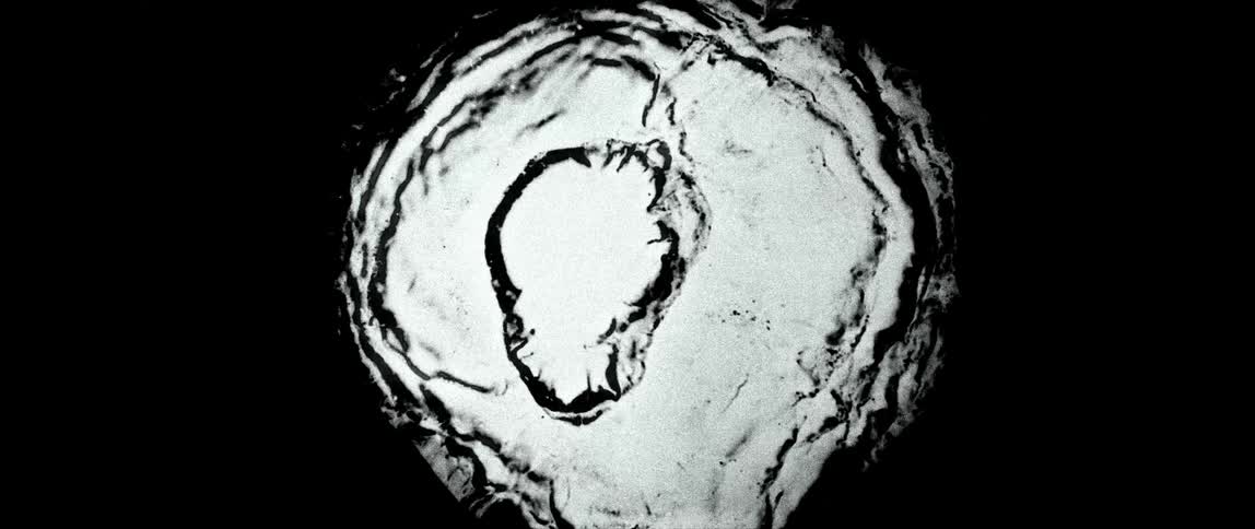 Extreme close up of a whitish liquid against a black background