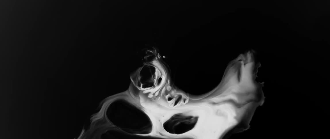 An abstract pattern of white and black swirls resembling smoke or liquid on a dark background