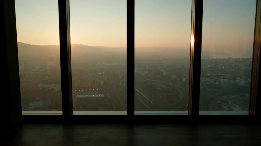 Landscape of an urban city with mountains on the horizon seen through a window