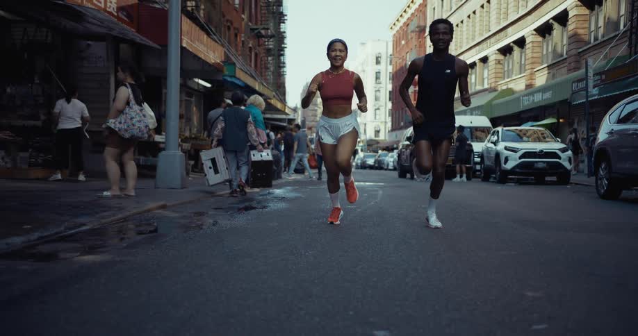 Woman and a man running on the street through the city