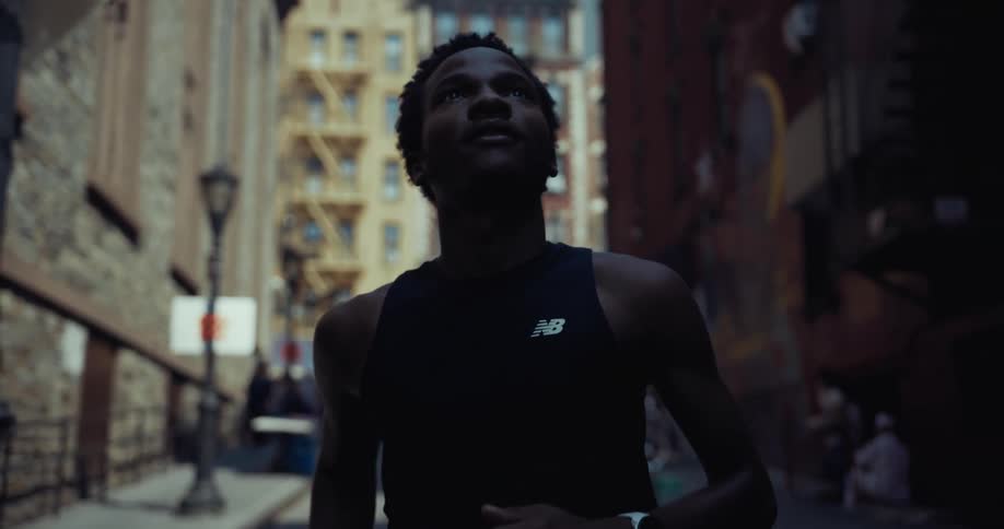 Man in tank top running through city