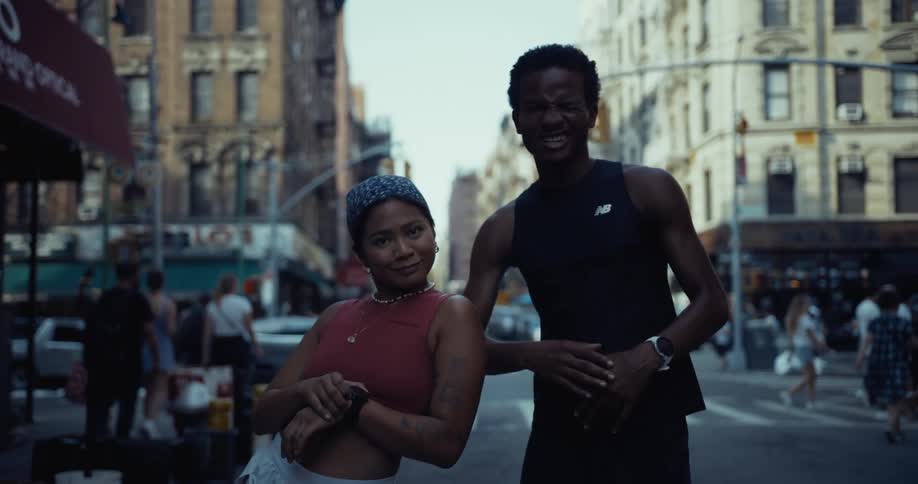 Man and a woman posing with happy facial expression in the middle of a street in a metropolis