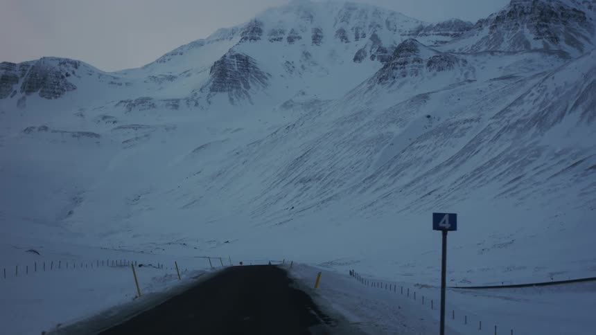 The mountain by the path is covered in snow